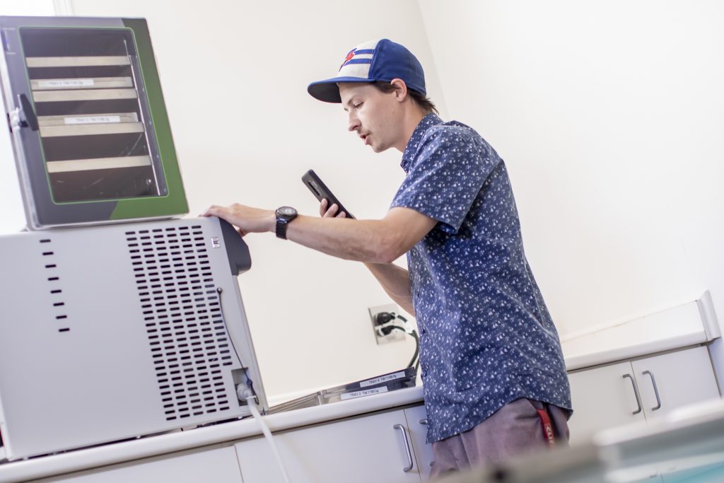 Whistler Technologies team member using the touchscreen on a freeze dryer