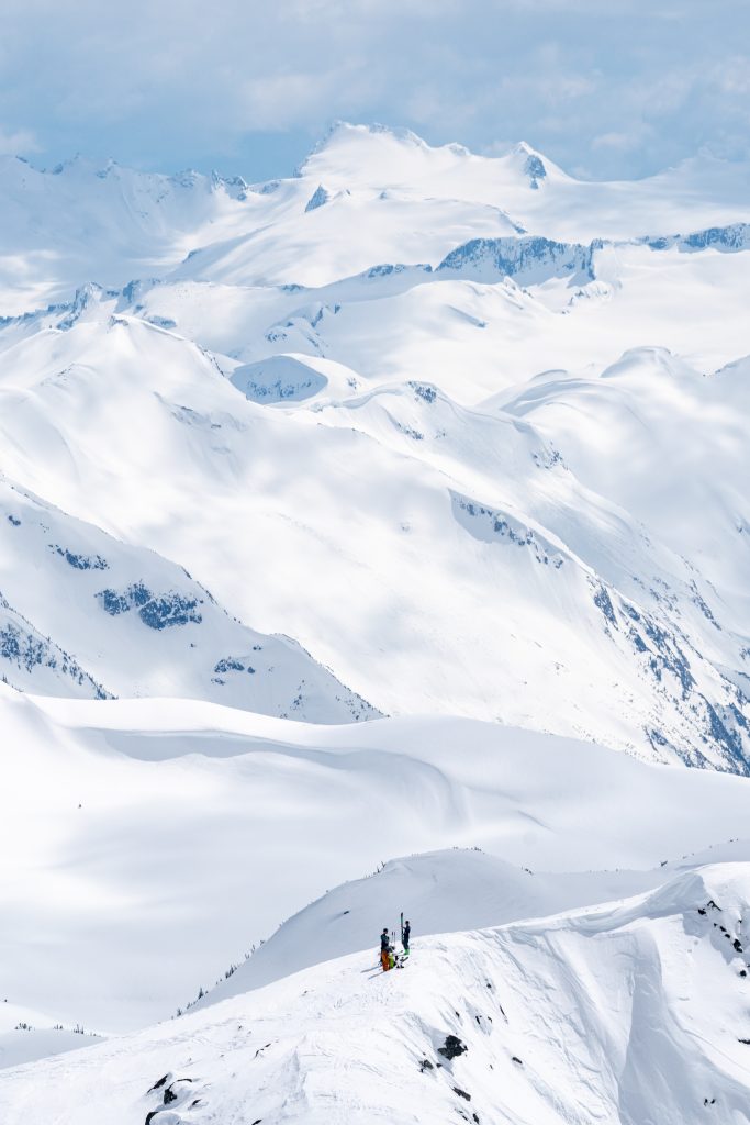 Backcountry skiers transitioning with mountains in the background in Whistler, BC