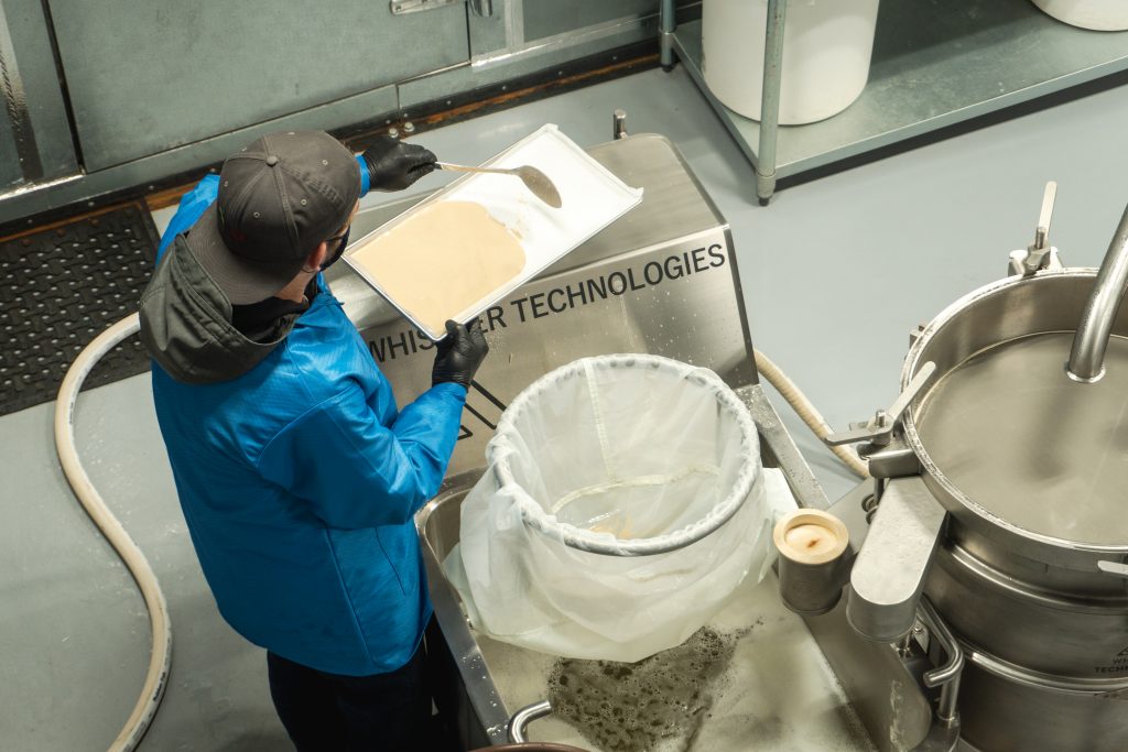 An operator scooping bubble hash onto a tray